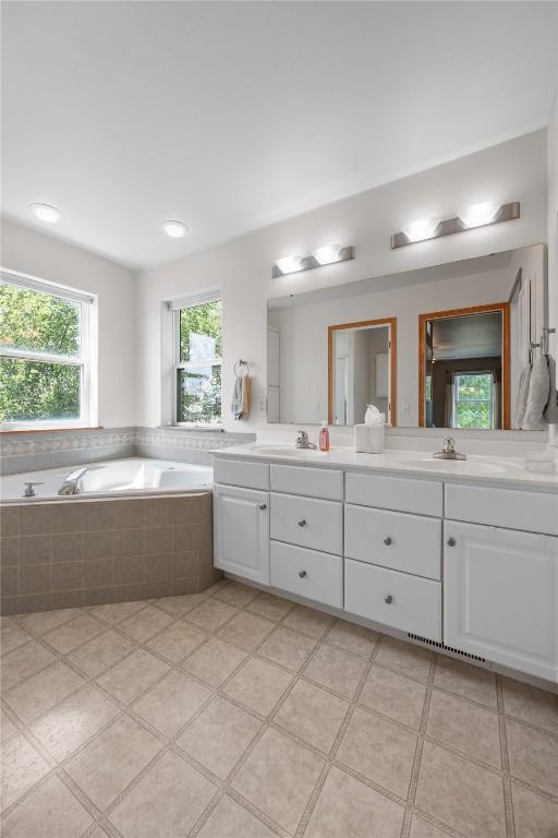 712 Willow Ct, Solon, IA 52333 - bathroom featuring double vanity and a bath