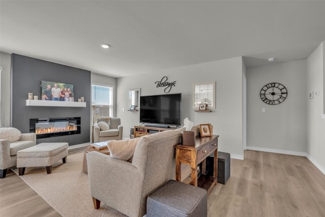 305 Sumac Dr, Palo, IA 52324 - living area featuring light wood-style flooring, a glass covered fireplace, and recessed lighting