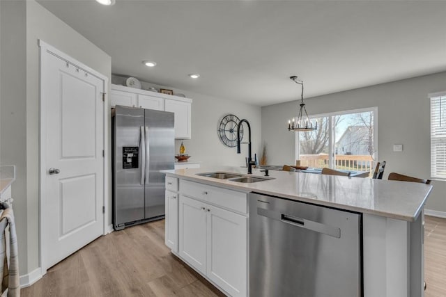 305 Sumac Dr, Palo, IA 52324 - kitchen with appliances with stainless steel finishes, a chandelier, white cabinetry, an island with sink, and light wood finished floors