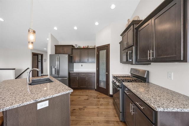 210 Northgate St NW, Shellsburg, IA 52332 - kitchen featuring stainless steel appliances, dark brown cabinets, light wood-style floors, recessed lighting, and light stone countertops