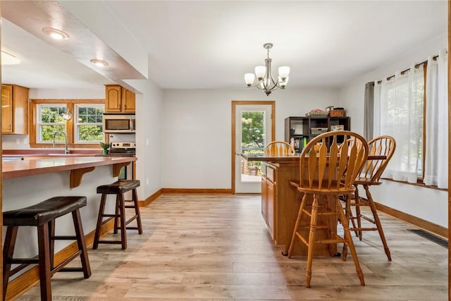 1207 E 4th St, Vinton, IA 52349 - dining space with a chandelier, light wood finished floors, and plenty of natural light