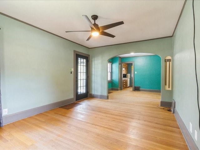 425 24th NE, Cedar Rapids, IA 52402 - empty room featuring arched walkways, light wood finished floors, a ceiling fan, and ornamental molding