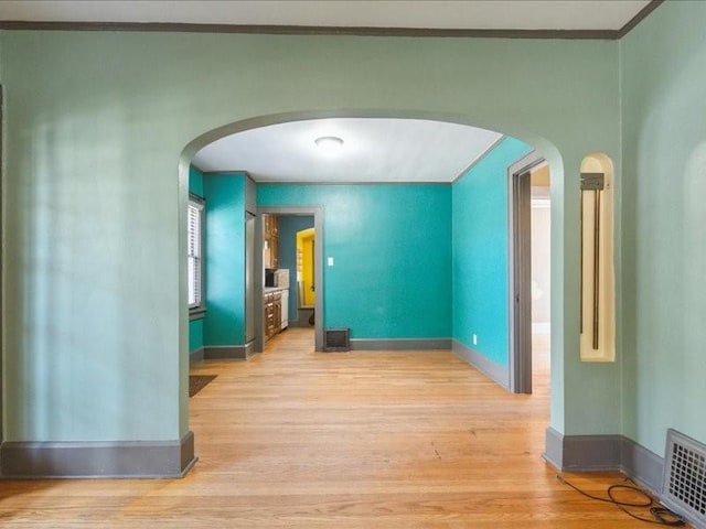 425 24th NE, Cedar Rapids, IA 52402 - unfurnished room featuring light wood-type flooring, arched walkways, and ornamental molding