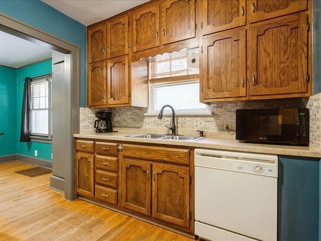 425 24th NE, Cedar Rapids, IA 52402 - kitchen featuring white dishwasher, black microwave, decorative backsplash, and brown cabinetry