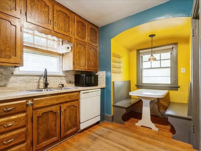 425 24th NE, Cedar Rapids, IA 52402 - kitchen with dishwasher, black microwave, brown cabinets, tasteful backsplash, and pendant lighting