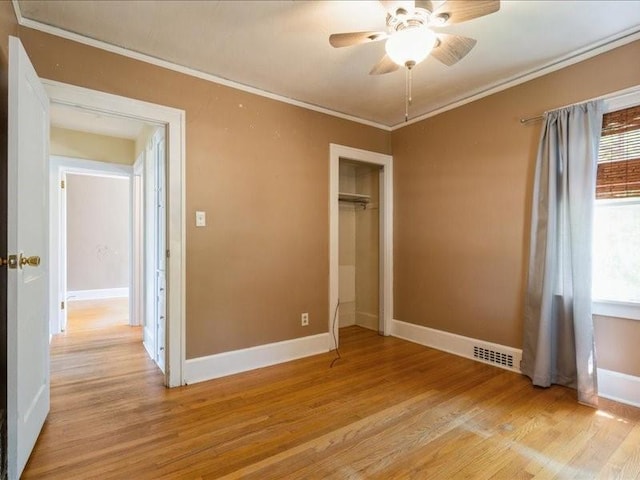 425 24th NE, Cedar Rapids, IA 52402 - unfurnished bedroom featuring ornamental molding, light wood finished floors, multiple windows, a closet, and a ceiling fan