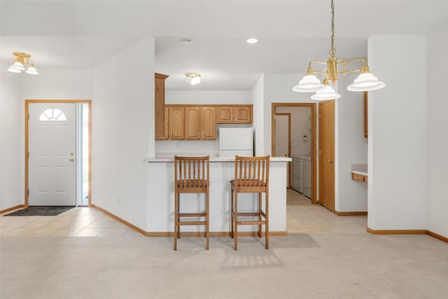 819 Winterberry Pl NE, Cedar Rapids, IA 52402 - kitchen featuring freestanding refrigerator, a peninsula, a kitchen bar, light colored carpet, and recessed lighting