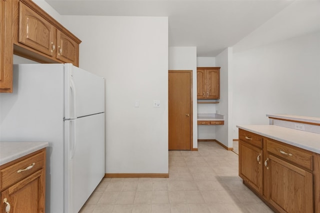 819 Winterberry Pl NE, Cedar Rapids, IA 52402 - kitchen featuring freestanding refrigerator, light countertops, brown cabinets, and light floors