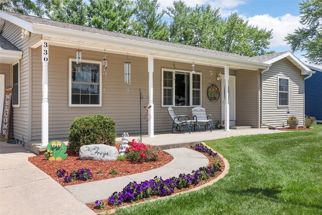 330 E S St, Lisbon, IA 52253 - view of front of home with covered porch, a front lawn, and roof with shingles