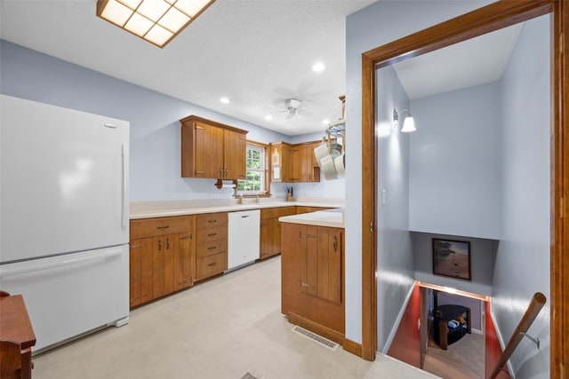 330 E S St, Lisbon, IA 52253 - kitchen with white appliances, light countertops, ceiling fan, recessed lighting, and brown cabinetry