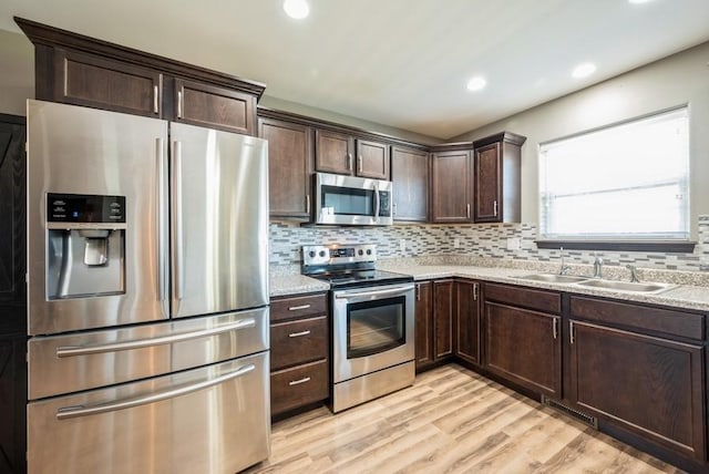 3212 Sherwood Pl, Marion, IA 52302 - kitchen featuring appliances with stainless steel finishes, dark brown cabinetry, light wood-style floors, tasteful backsplash, and recessed lighting