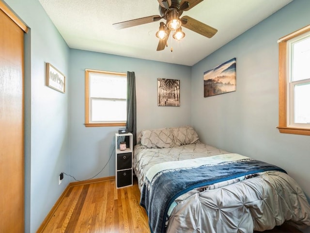 820 Hillview Dr, Marion, IA 52302 - bedroom with light wood-style floors, multiple windows, and ceiling fan