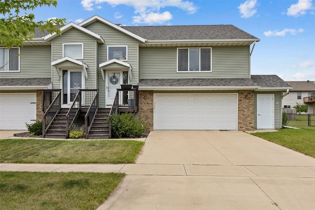 609 W Orange St, West Branch, IA 52358 - view of front of property with an attached garage, brick siding, concrete driveway, and a shingled roof