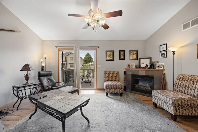 609 W Orange St, West Branch, IA 52358 - living room featuring ceiling fan, light wood-style flooring, a fireplace, and vaulted ceiling