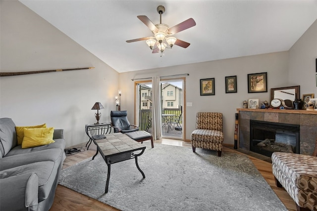 609 W Orange St, West Branch, IA 52358 - living area featuring a ceiling fan, a tiled fireplace, lofted ceiling, and wood finished floors