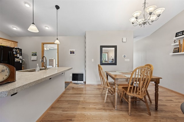 609 W Orange St, West Branch, IA 52358 - dining space with light wood finished floors, a chandelier, and ceiling fan