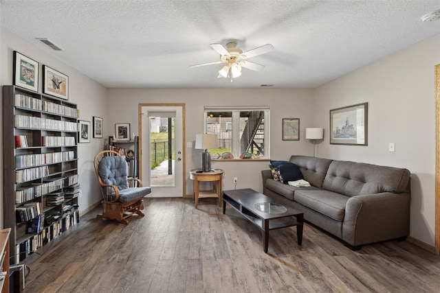 609 W Orange St, West Branch, IA 52358 - living area featuring wood finished floors, a ceiling fan, and a textured ceiling