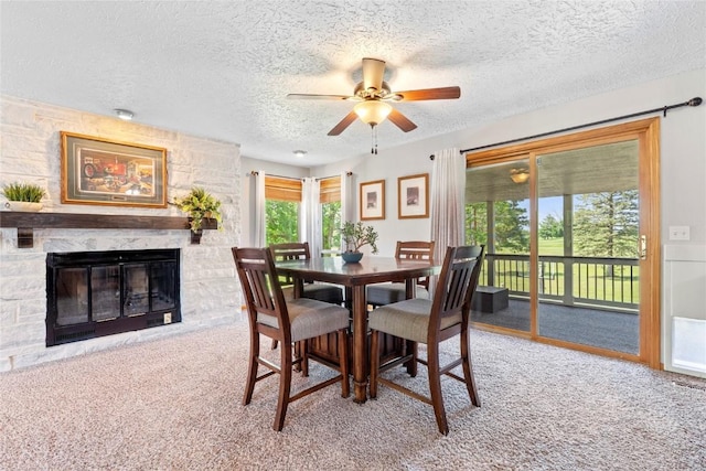 101 Golf Cir, Winfield, IA 52659 - carpeted dining room with ceiling fan, a textured ceiling, and a stone fireplace