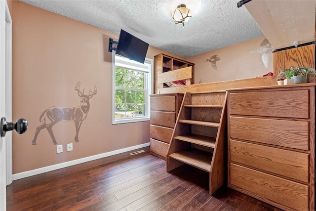101 Golf Cir, Winfield, IA 52659 - bedroom featuring a textured ceiling and dark wood-type flooring