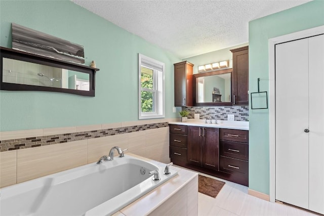 101 Golf Cir, Winfield, IA 52659 - bathroom with a bath, vanity, a textured ceiling, and backsplash