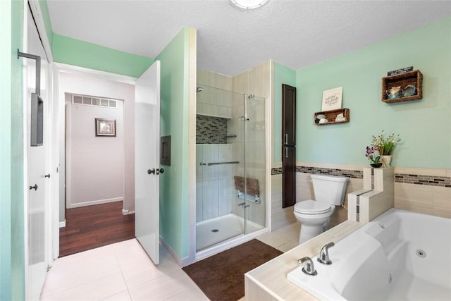 101 Golf Cir, Winfield, IA 52659 - bathroom with a stall shower, a whirlpool tub, tile patterned flooring, and a textured ceiling