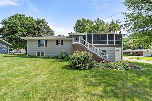 101 Golf Cir, Winfield, IA 52659 - rear view of house with stairway, a sunroom, and a yard