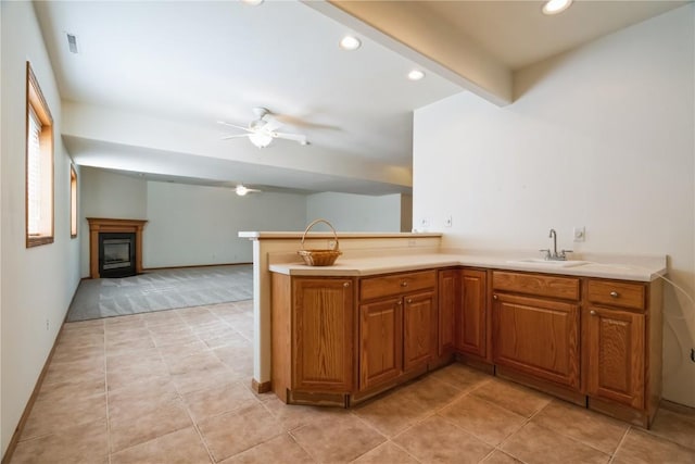 4118 Paradise Ct NW, Cedar Rapids, IA 52405 - kitchen featuring ceiling fan, brown cabinetry, a fireplace, recessed lighting, and a peninsula