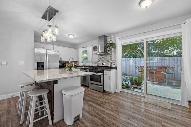 665 Hillview Dr, Marion, IA 52302 - kitchen with appliances with stainless steel finishes, wall chimney exhaust hood, a center island, white cabinets, and tasteful backsplash