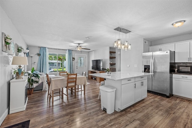 665 Hillview Dr, Marion, IA 52302 - kitchen featuring stainless steel refrigerator with ice dispenser, black microwave, a textured ceiling, dark wood-style flooring, and a kitchen island