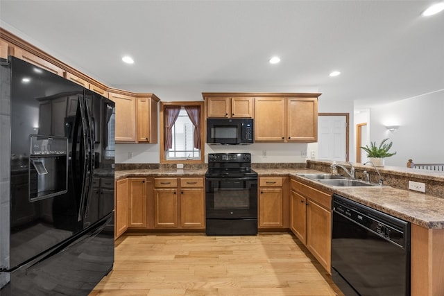 2054 Shortgrass Pl, Marion, IA 52302 - kitchen with black appliances, a peninsula, light wood finished floors, recessed lighting, and brown cabinetry