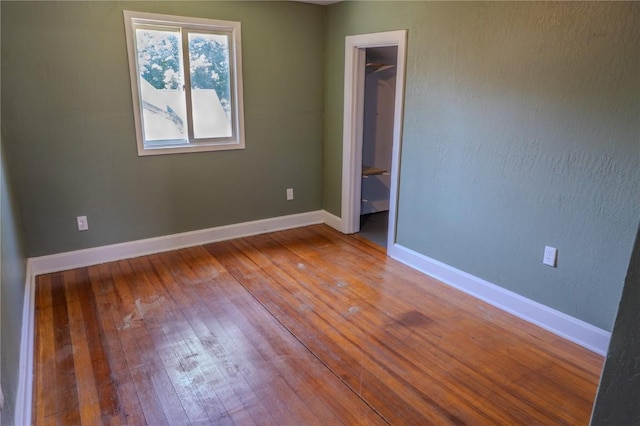 701 Hall Ave, Lowden, IA 52255 - unfurnished bedroom with hardwood / wood-style flooring and baseboards