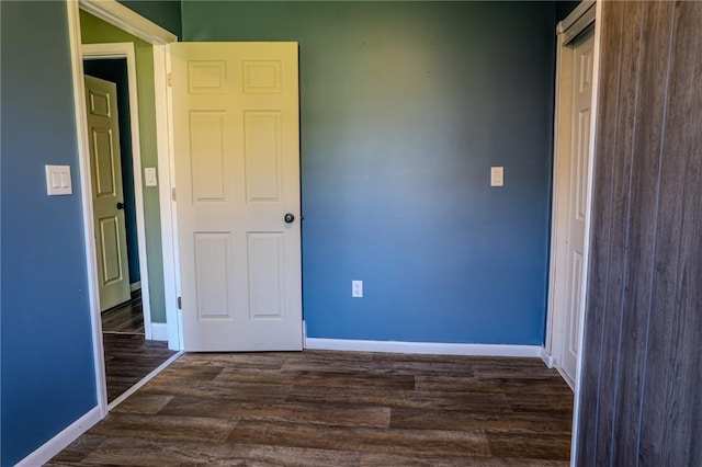 701 Hall Ave, Lowden, IA 52255 - unfurnished bedroom featuring dark wood finished floors and baseboards