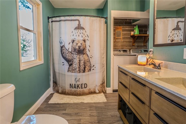 701 Hall Ave, Lowden, IA 52255 - bathroom with washer and clothes dryer, wood finished floors, double vanity, and a shower with shower curtain