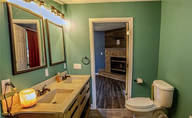 701 Hall Ave, Lowden, IA 52255 - bathroom with double vanity, a large fireplace, and wood finished floors
