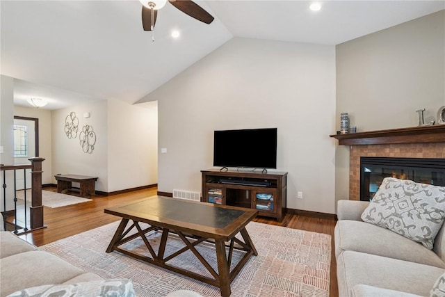 8313 Monterey Dr NE, Cedar Rapids, IA 52402 - living room with lofted ceiling, ceiling fan, wood finished floors, recessed lighting, and a tiled fireplace