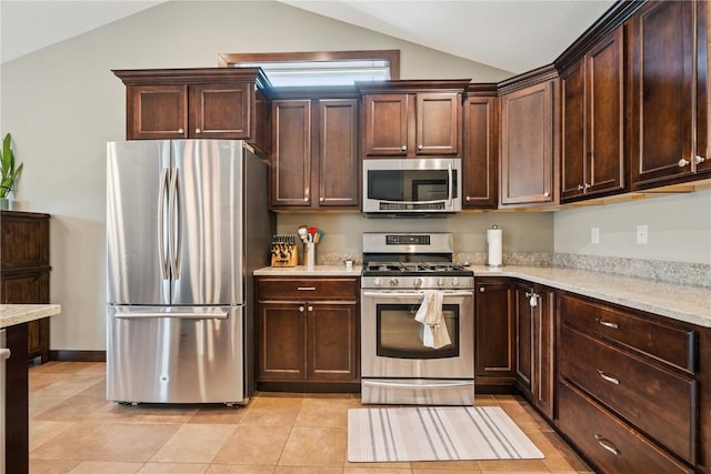 8313 Monterey Dr NE, Cedar Rapids, IA 52402 - kitchen with stainless steel appliances, lofted ceiling, light stone counters, and dark brown cabinets