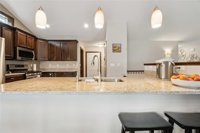 8313 Monterey Dr NE, Cedar Rapids, IA 52402 - kitchen with stainless steel appliances, dark brown cabinetry, decorative light fixtures, a kitchen breakfast bar, and light stone counters