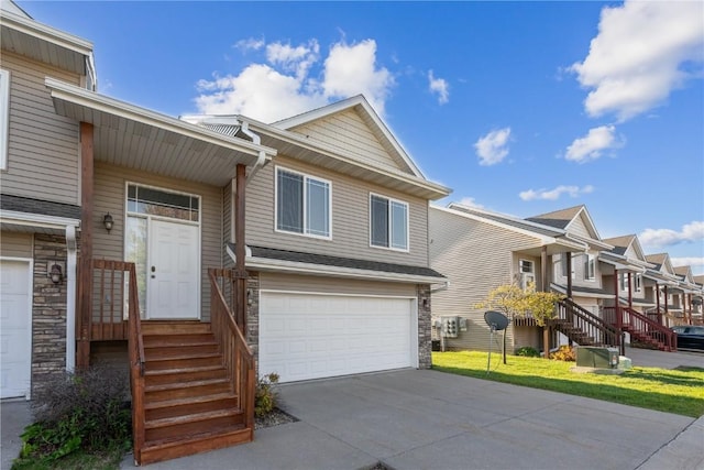 1810 Goose Lake Cir, North Liberty, IA 52317 - view of front facade featuring stone siding, a garage, a residential view, and driveway