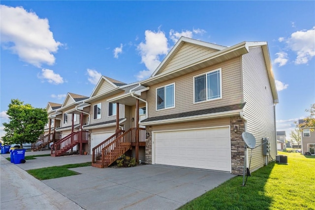 1810 Goose Lake Cir, North Liberty, IA 52317 - view of front facade with stone siding, an attached garage, a front lawn, driveway, and a residential view