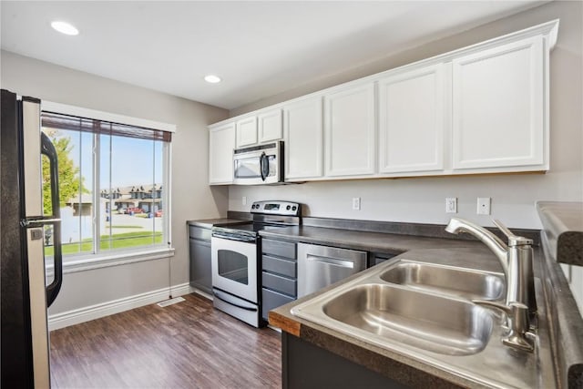 1810 Goose Lake Cir, North Liberty, IA 52317 - kitchen with appliances with stainless steel finishes, dark wood-type flooring, white cabinets, dark countertops, and recessed lighting