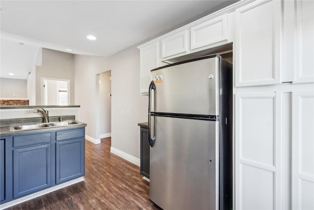 1810 Goose Lake Cir, North Liberty, IA 52317 - kitchen with freestanding refrigerator, dark wood-style flooring, white cabinets, blue cabinets, and recessed lighting