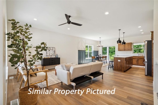4620 Preston Ln, Iowa City, IA 52246 - living area with light wood-style floors, ceiling fan, plenty of natural light, recessed lighting, and a chandelier