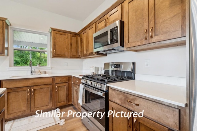 4620 Preston Ln, Iowa City, IA 52246 - kitchen featuring stainless steel appliances, brown cabinetry, light countertops, and light wood-type flooring