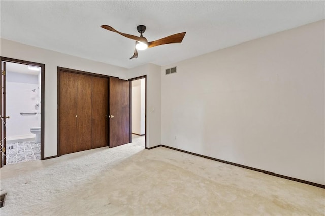 1131 Penkridge Dr, Iowa City, IA 52246 - unfurnished bedroom with light colored carpet, a closet, ensuite bathroom, and a ceiling fan