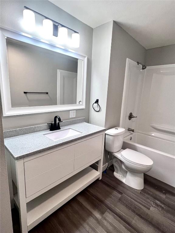 1705 NE Texas Ave, Cedar Rapids, IA 52402 - bathroom featuring wood finished floors, vanity, and shower / tub combination