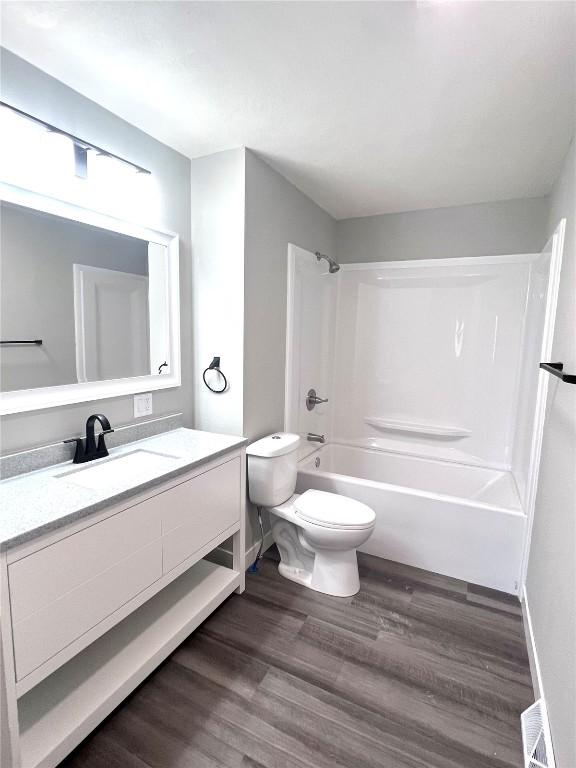 1705 NE Texas Ave, Cedar Rapids, IA 52402 - full bath with vanity, bathtub / shower combination, and wood finished floors
