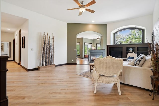 5512 Black Oak Dr NE, Cedar Rapids, IA 52411 - living area featuring ceiling fan, a glass covered fireplace, arched walkways, light wood-type flooring, and recessed lighting