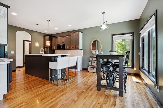 5512 Black Oak Dr NE, Cedar Rapids, IA 52411 - kitchen featuring stainless steel microwave, light wood-style floors, light countertops, backsplash, and recessed lighting