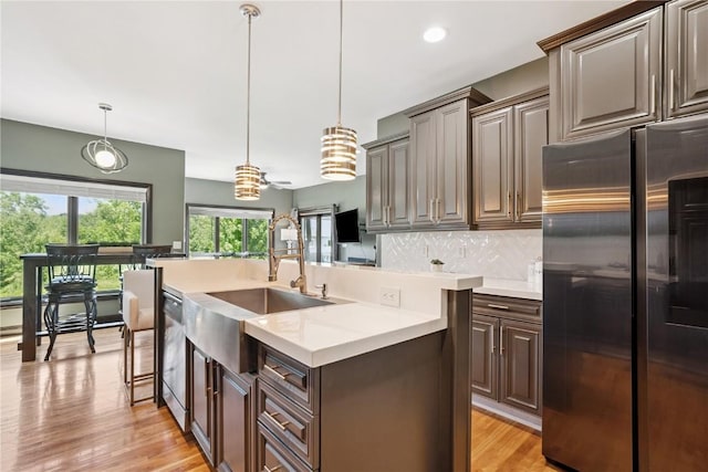 5512 Black Oak Dr NE, Cedar Rapids, IA 52411 - kitchen featuring stainless steel appliances, light countertops, backsplash, light wood-style floors, and an island with sink