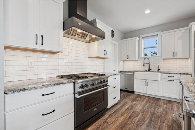 4395 Rec Dr, Marion, IA 52302 - kitchen featuring wall chimney range hood, stainless steel appliances, light stone countertops, white cabinets, and dark wood-style flooring